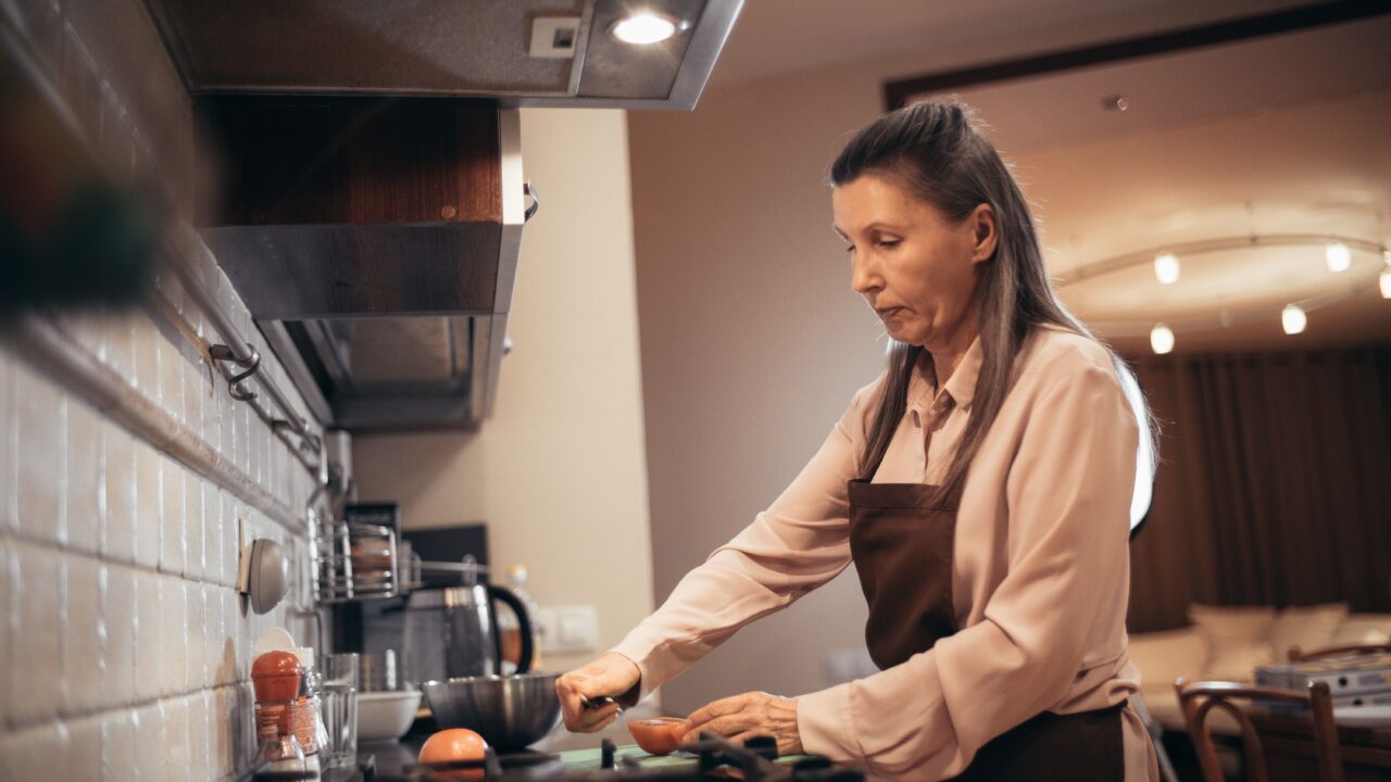 Woman over 40 cooking a healthy meal at home to support a stable metabolism