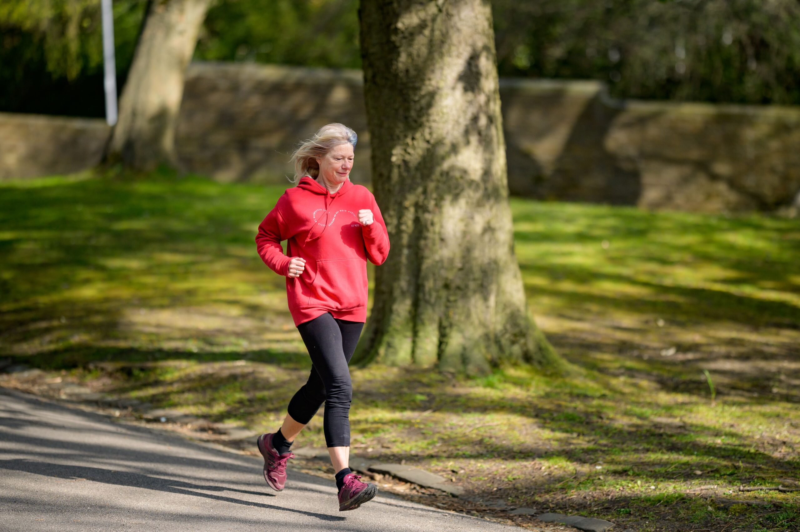 Mature woman jogging outdoors, an aerobic activity with strong evidence for reducing visceral fat