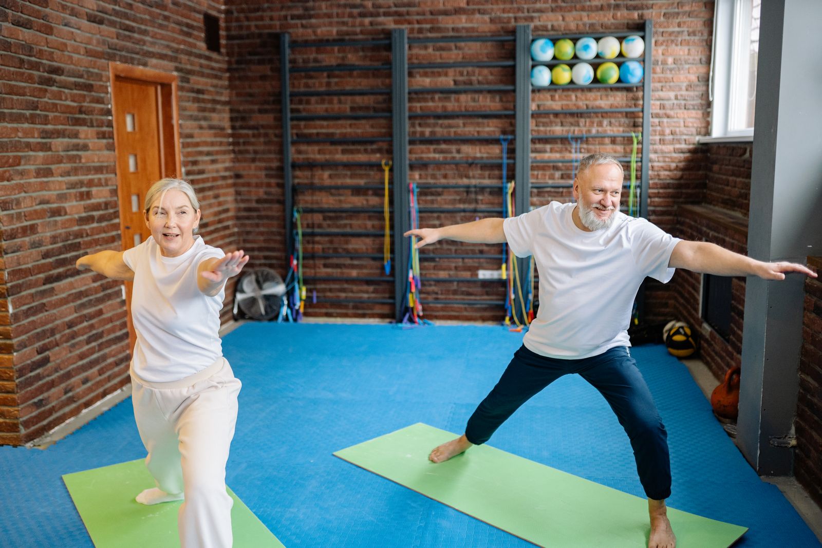 Older woman practicing a single-leg standing balance exercise in a gym
