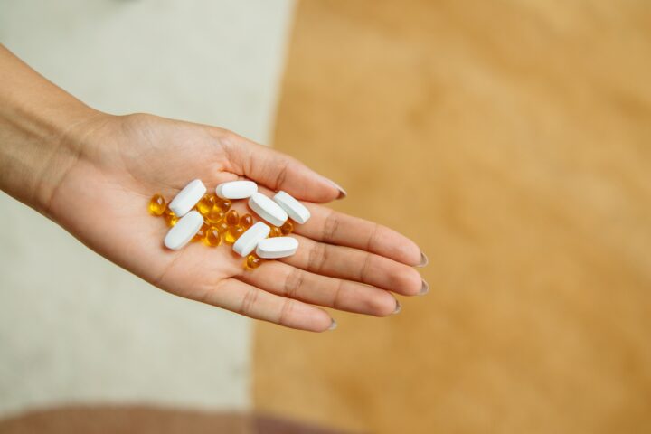 Hand holding supplement capsules, representing popular but often unproven anti-aging products