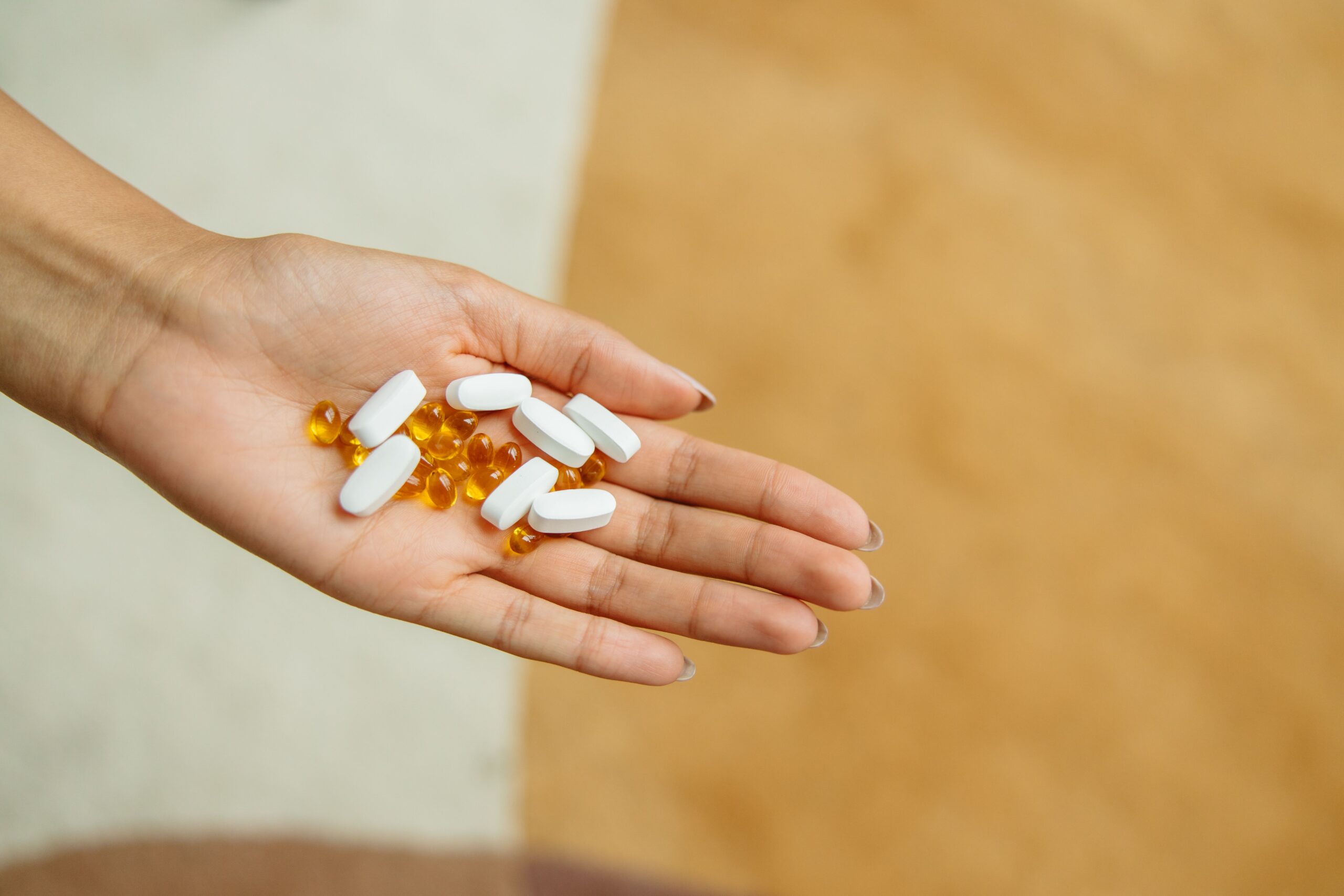 Hand holding supplement capsules, representing popular but often unproven anti-aging products