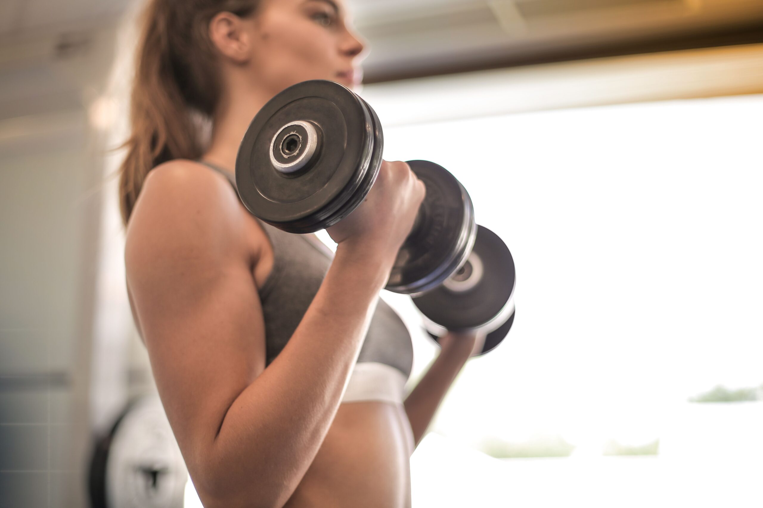 Woman over 40 doing dumbbell strength training to preserve muscle mass